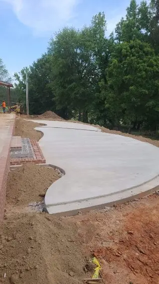 Curved plain grey concrete patio by OTM Concrete