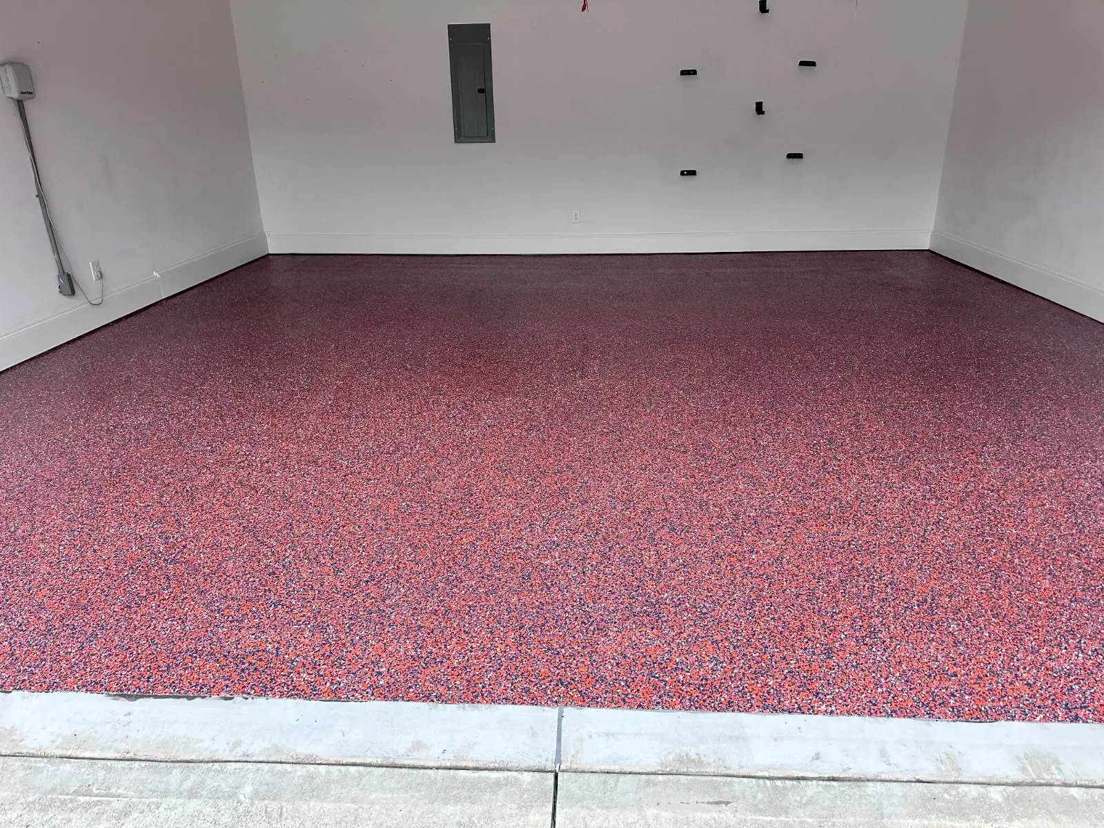 Glossy stained epoxy concrete floor with a deep copper finish by OTM Concrete