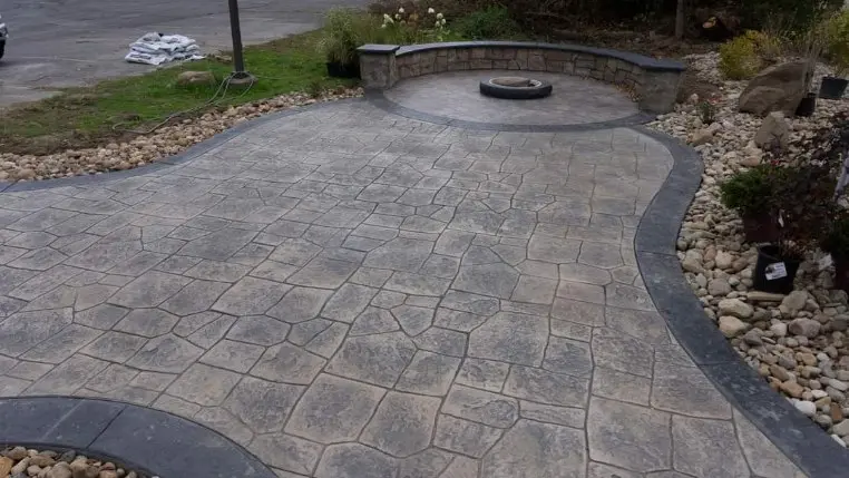 Stamped concrete patio in a finished outdoor living space by OTM Concrete