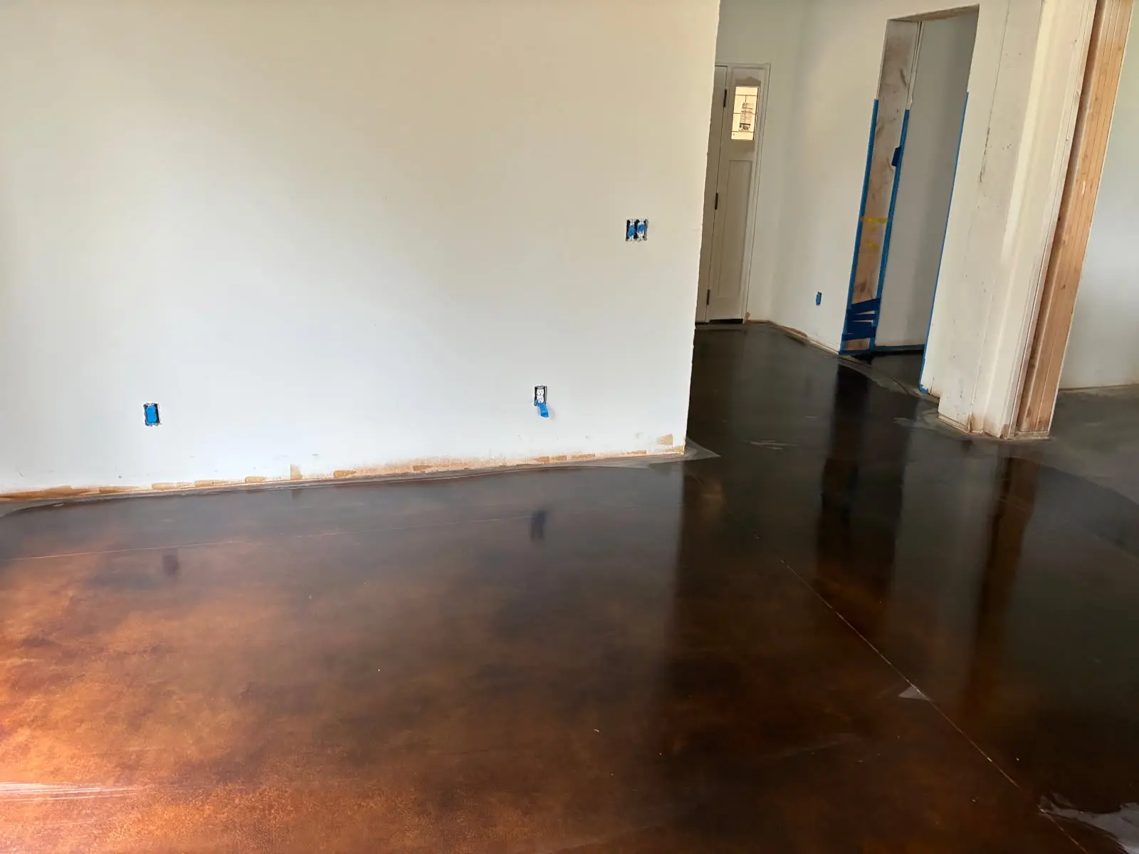Glossy stained epoxy concrete floor with a deep copper finish by OTM Concrete