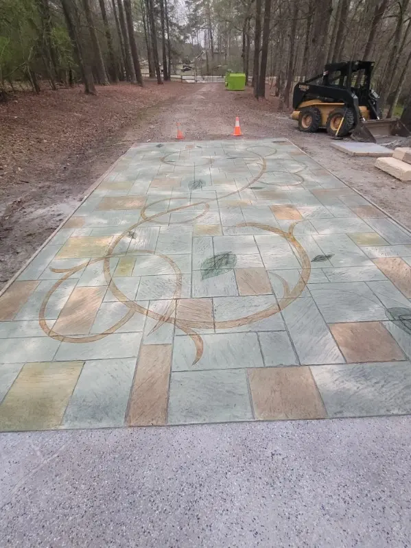 Stamped concrete driveway leading to an outdoor living area by OTM Concrete